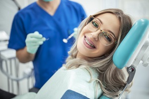 girl with braces smiling at camera at dentist office